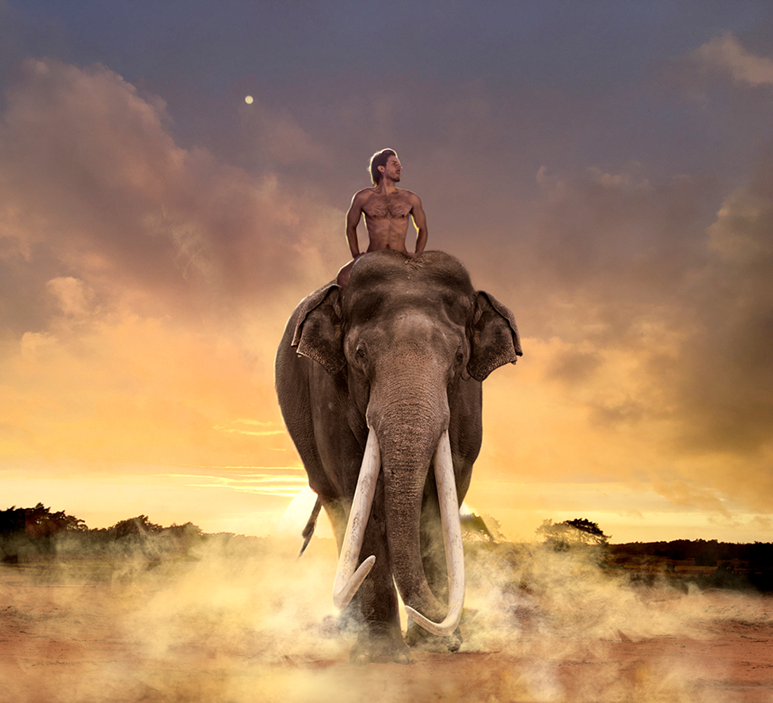nude man riding on an elephant towards the camera